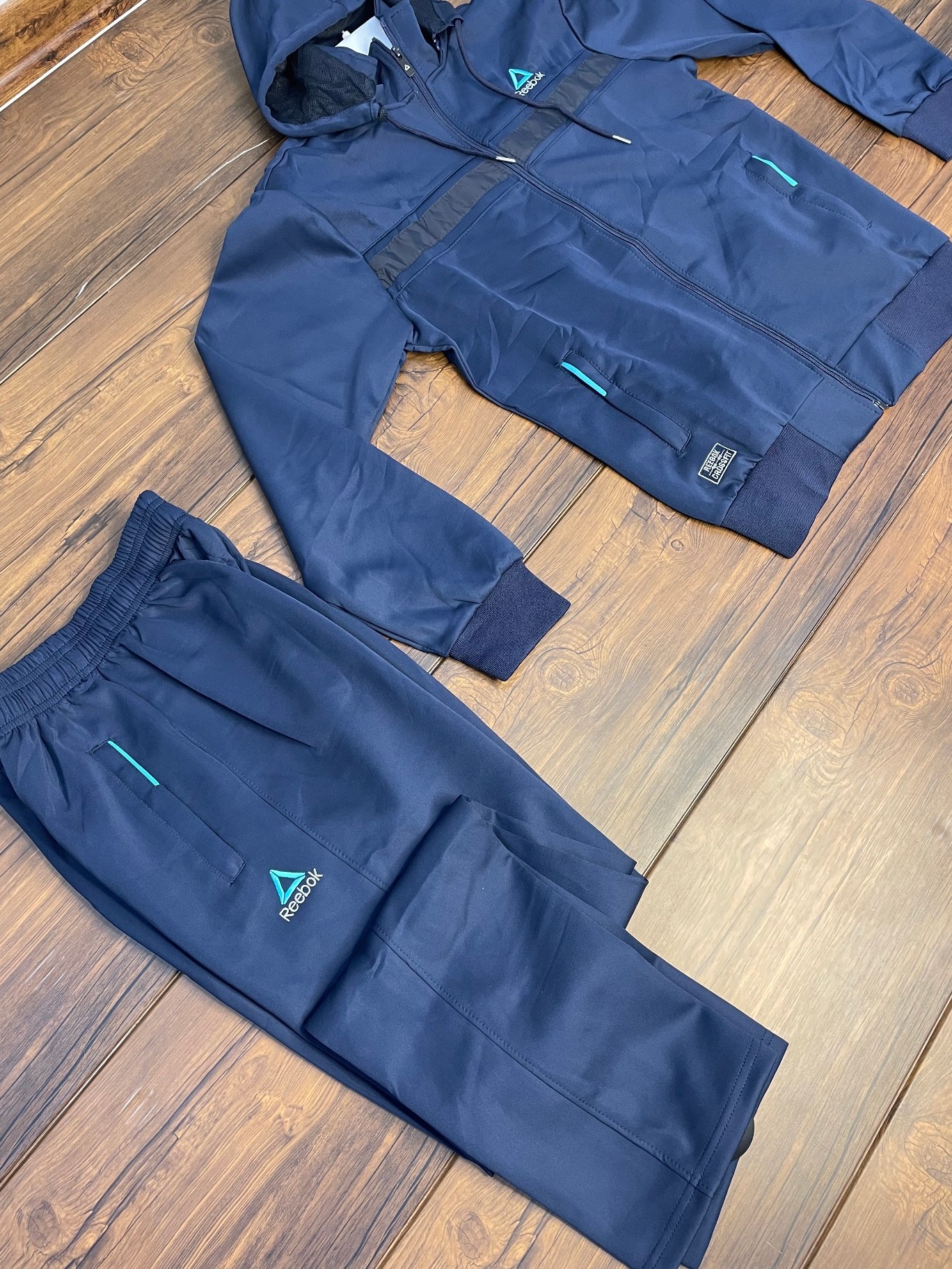 ست لباس ورزشی مردانه ریباک مدل استرج اعلا رنگ سیاه و سرمه ای